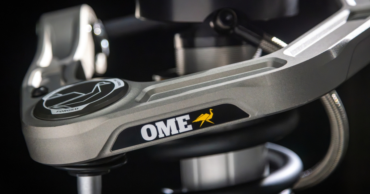 Close-up of the Old Man Emu Forged Billet upper control arm showing the OME badge on the gray hard-anodized finish