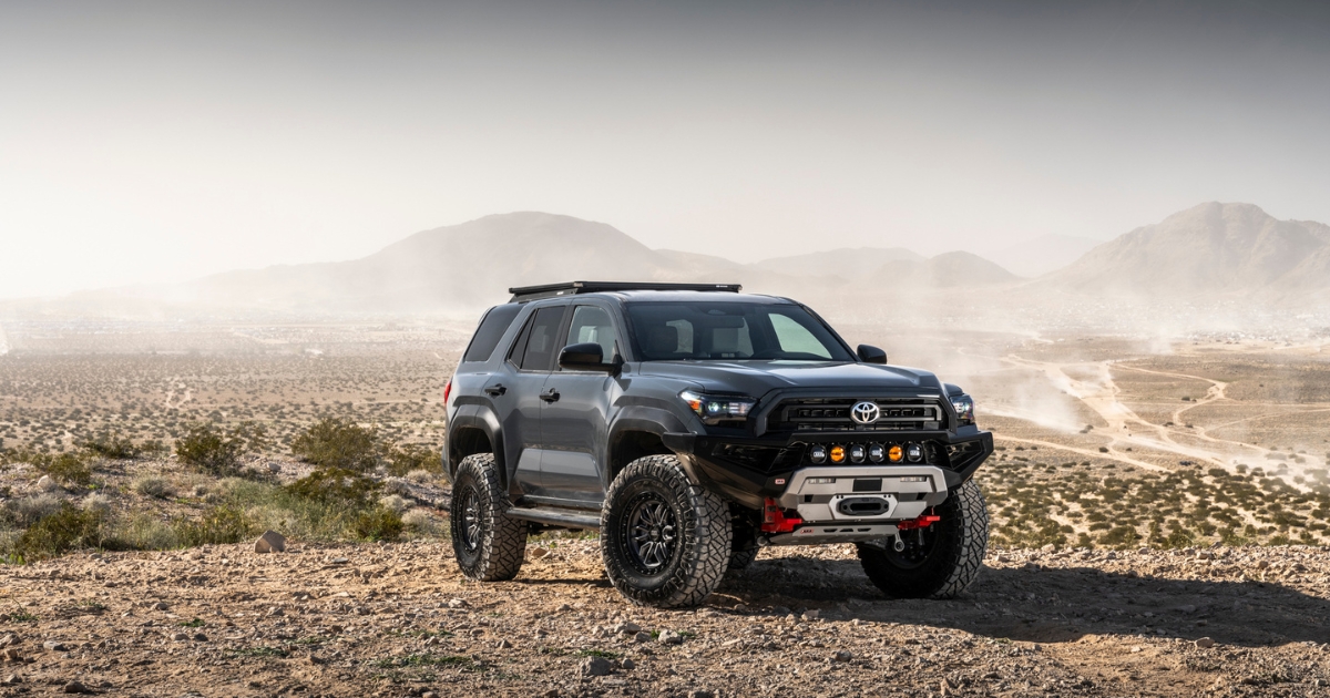 Gray lifted Toyota 4Runner with a Old Man Emu Forged Billet UCA, light bar, and large all-terrain tires parked on a rocky desert trail