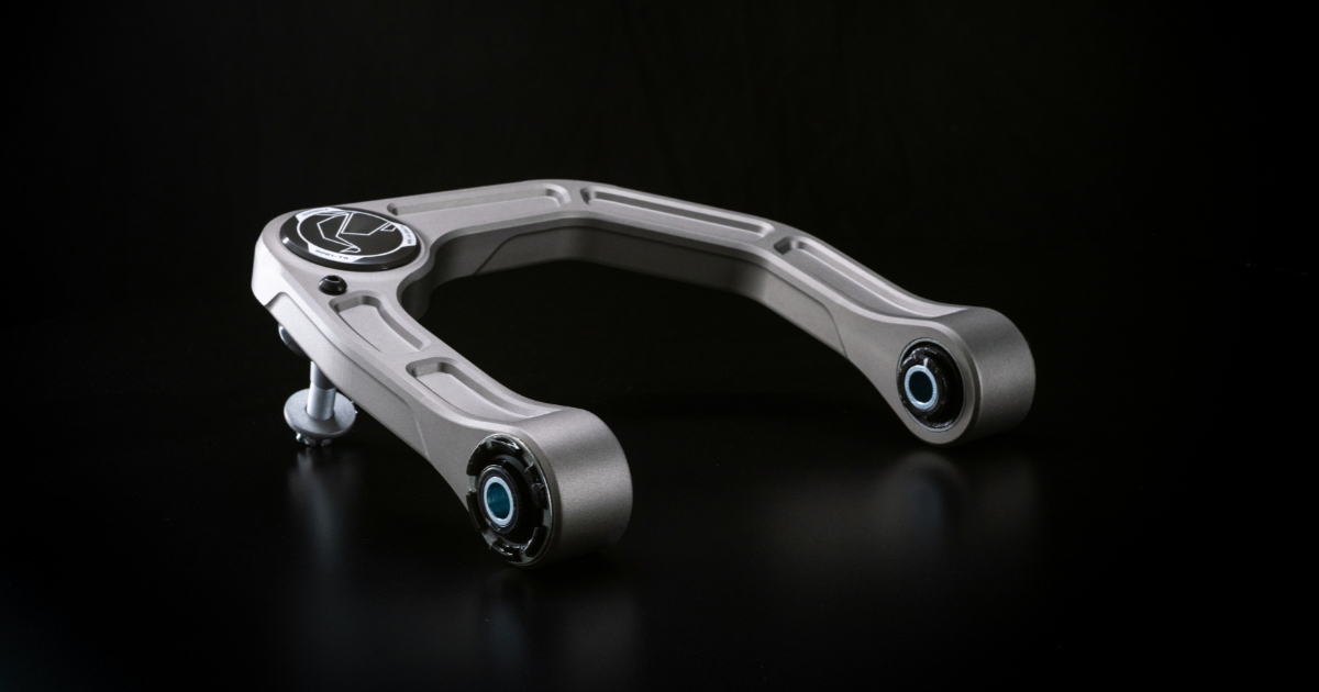 Old Man Emu Forged Billet upper control arm, showing both sealed bushings, the forged ball joint cap, and the gray hard-anodized finish